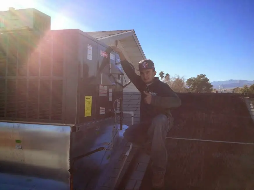 HVAC technician performing Heat Pump Repair on a rooftop unit in Lake Norman of Iredell